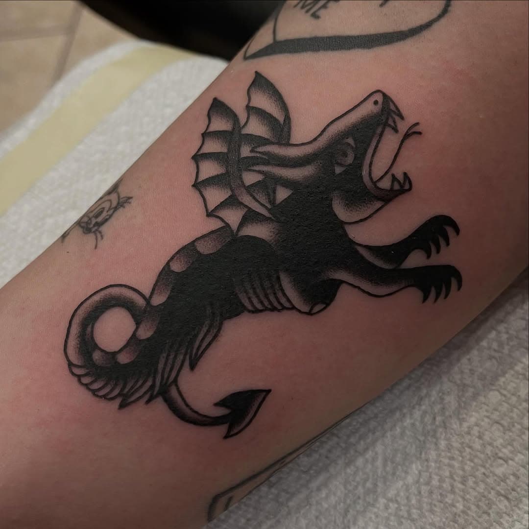 Winged mythical beast on arm