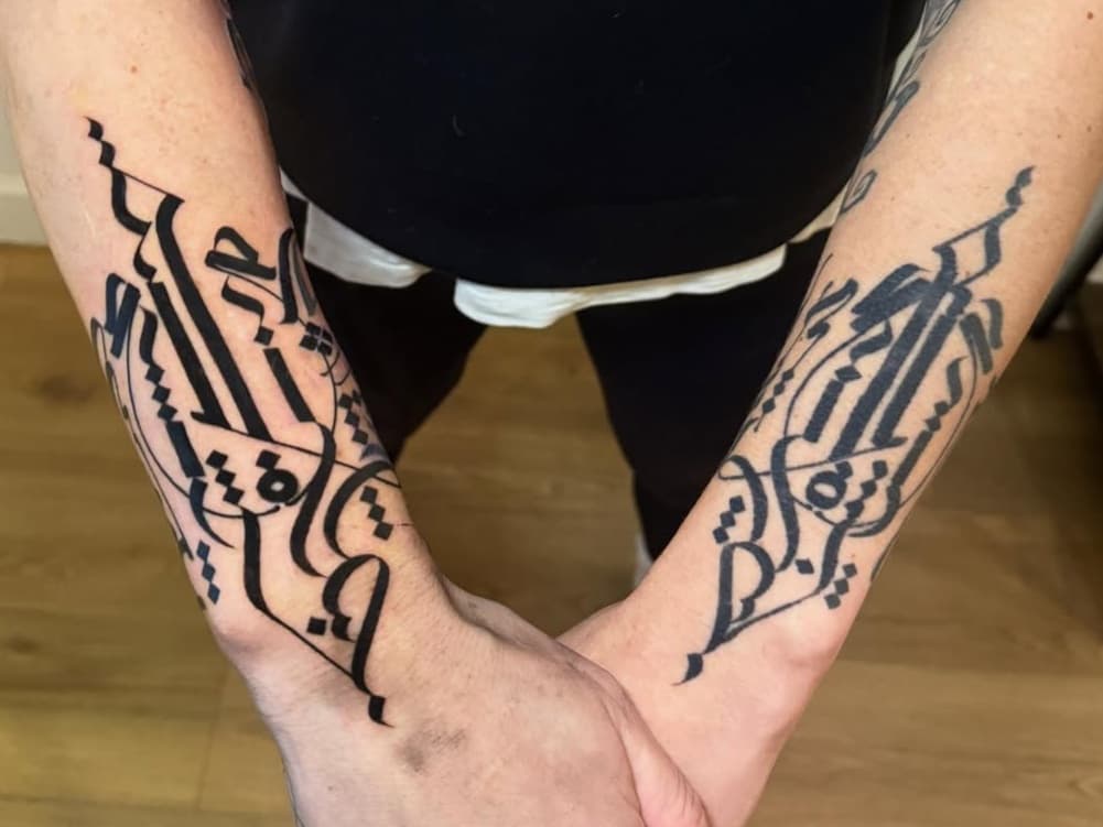 Abstract calligraphic script on forearms