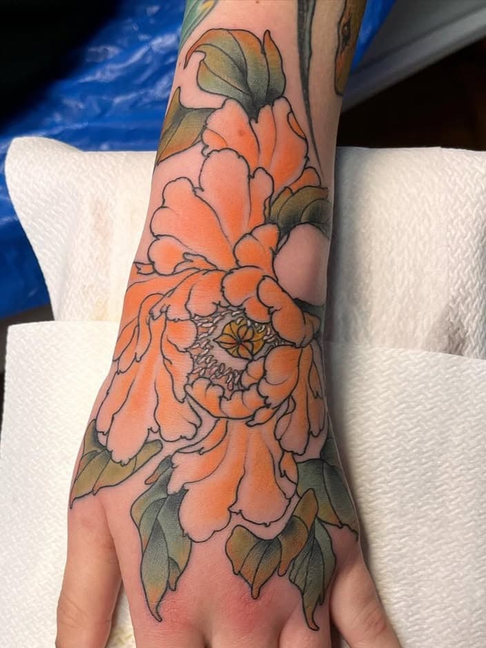 Vibrant orange peony with foliage