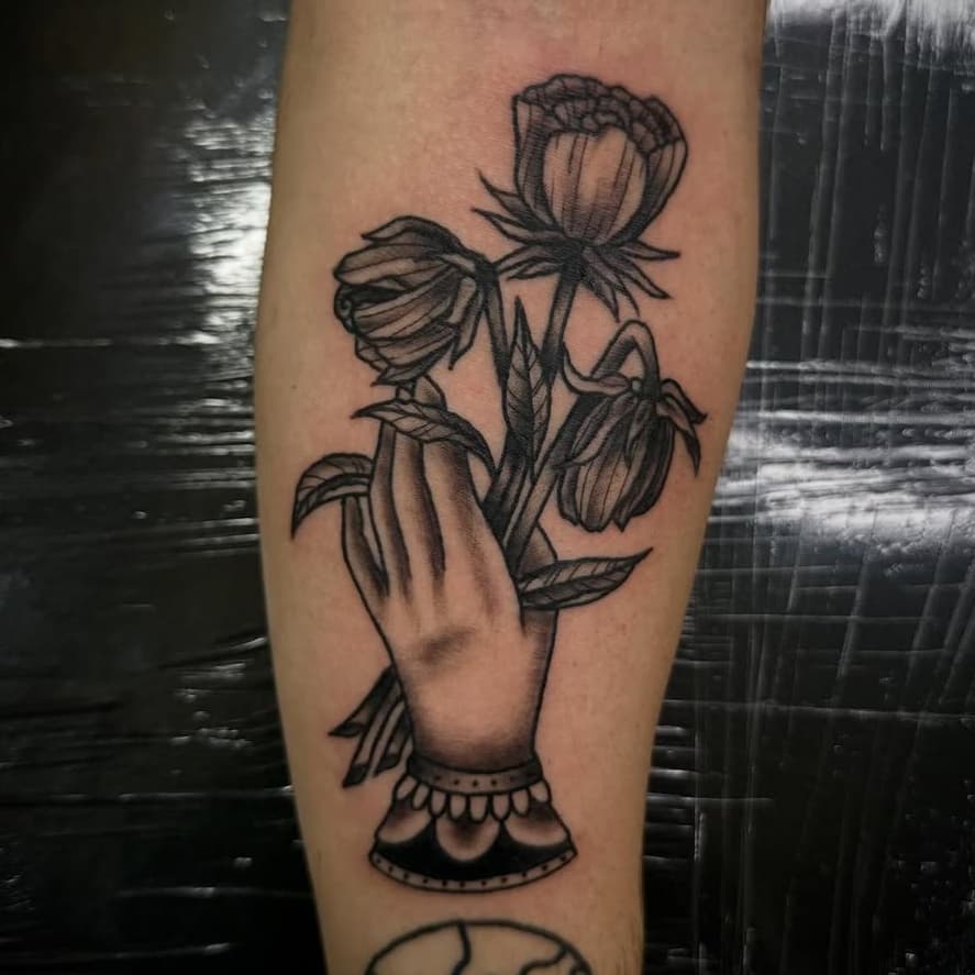 Clutching flowers with skull below